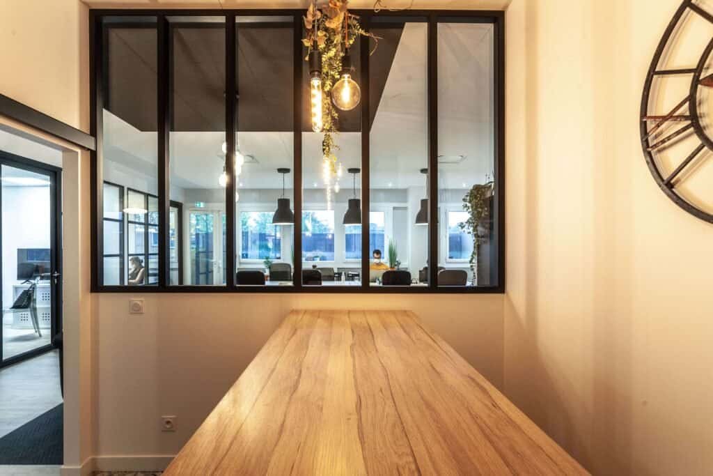 Salle de restauration en bois avec vue depuis la verrière sur la salle de réunion centrale